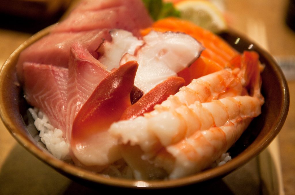 Plato de chirashi sushi, arroz cocido con pescado crudo encima (gambas, salmón, pulpo, atún)
