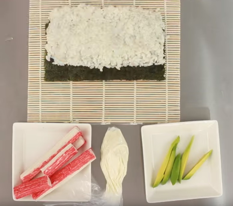 Disposición del arroz o gohan encima del alga nori para preparar el uramaki